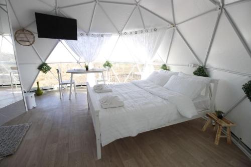 um quarto com uma cama branca numa tenda em Heart Of The Hills em Golan Heights