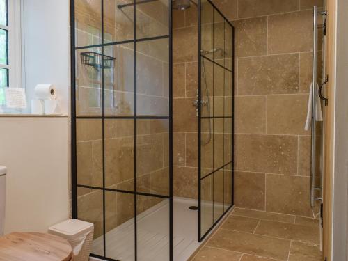 a shower with a glass enclosure in a bathroom at Gardeners Cottage in Mudford