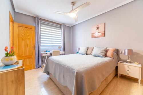 ein Schlafzimmer mit einem großen Bett und einem Fenster in der Unterkunft Casa Del Sol Naciente in Gran Alacant