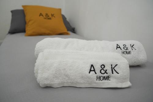 Una cama con una toalla blanca con las palabras axk home en A&K HOME, en Ceglie Messapica