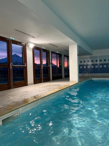 - une grande piscine dans un bâtiment doté de fenêtres dans l'établissement Appartement 6 places aux pieds des pistes avec piscine, wifi et parking privé, salle de bain refaite à neuf, à Orcières