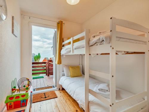 a bedroom with bunk beds and a balcony at Chalet 56 in Kingsdown