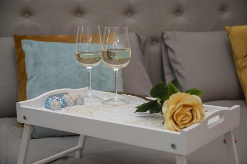 two glasses of wine on a tray on a bed at Cuore di Relais e Châteaux 5 STELLE in Bellinzona CITY OF CASTLES -By EasyLife Swiss in Bellinzona