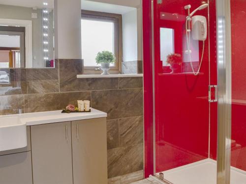 y baño con ducha de color rojo y lavamanos. en Koi Keep - Ukc1909 en Doddington