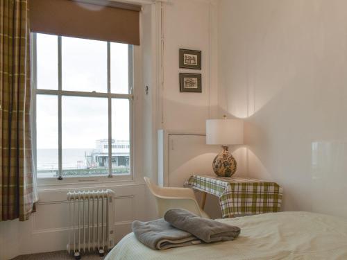 a bedroom with a bed and a window and a table at Flat 3 Sea View - Ukc4219 in Lowestoft