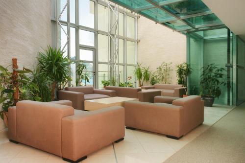 a lobby with couches and plants in a building at Monte Casa SPA & Wellness in Petrovac na Moru