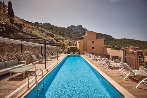 a swimming pool with lounge chairs and a building at Maristel Hotel & Spa - Adults Only in Estellencs