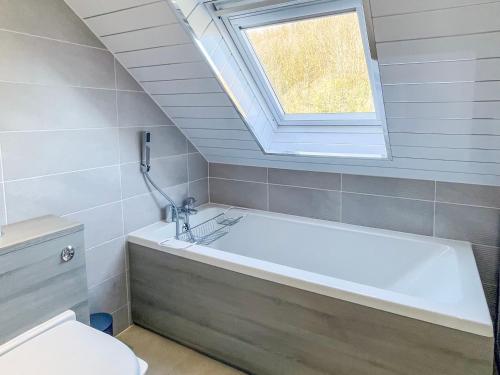 a bathroom with a bath tub and a window at Thornbank in Millport