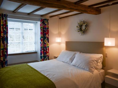 a bedroom with a white bed and a window at The Snug in Kirkby Lonsdale