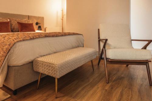 a bedroom with a bed and a chair at Casa da Ribeira in Marco de Canavezes