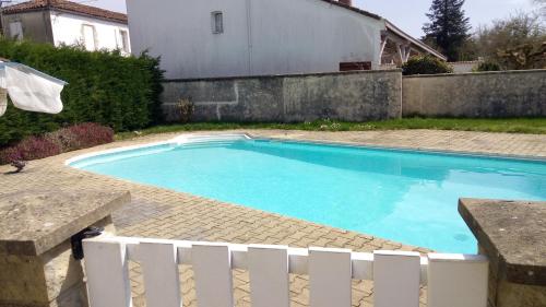 a swimming pool in a yard with a white fence at Hébergement 4 personnes Lencouacq in Lencouacq