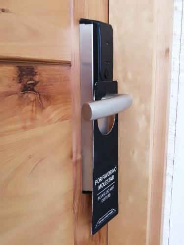 a metal door handle on a wooden door at Hotel Costanera in Puerto Natales