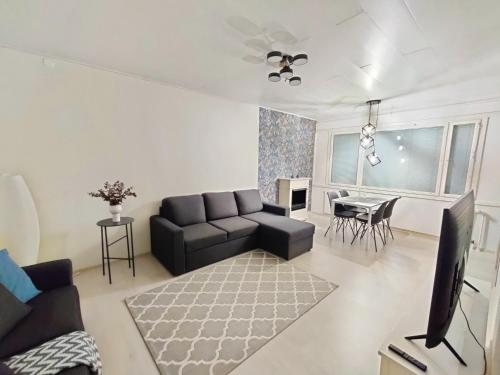 uma sala de estar com um sofá e uma mesa em Nika Apartments em Imatra