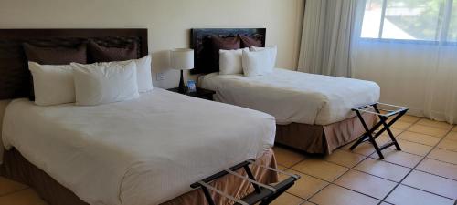 a hotel room with two beds and a window at Private family room in Coronado Luxury Club & Suites in Playa Coronado