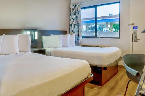 艾爾蒙地的住宿－洛杉磯6號汽車旅館- 艾爾蒙特，酒店客房设有两张床和窗户。