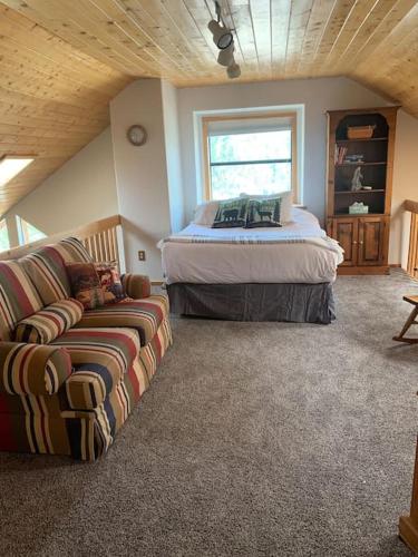 a bedroom with a bed and a couch in a room at Monroe’s Chateau with Hot Tub in Angel Fire
