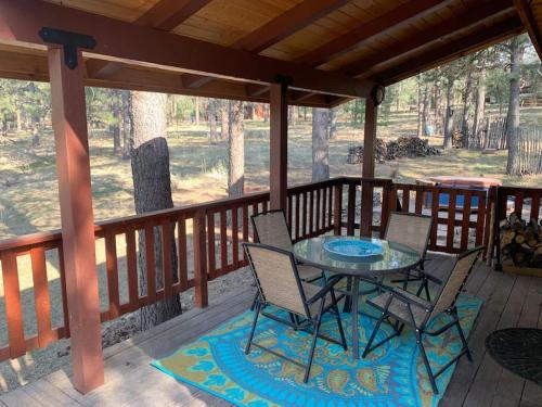 a patio with a table and chairs on a deck at Monroe’s Chateau with Hot Tub in Angel Fire