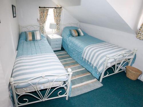 two beds in a attic room with stairs at Buttercup Cottage - Ukc2847 in Blakeney