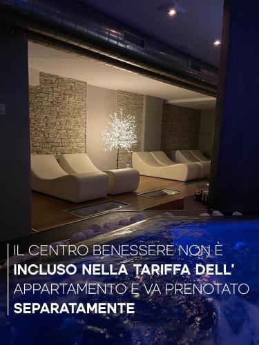 a room with white couches and a brick wall at Residence Verdeblu in Arco