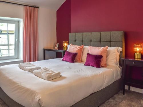 a bedroom with a large bed with purple walls at Bridge House in Holmfirth