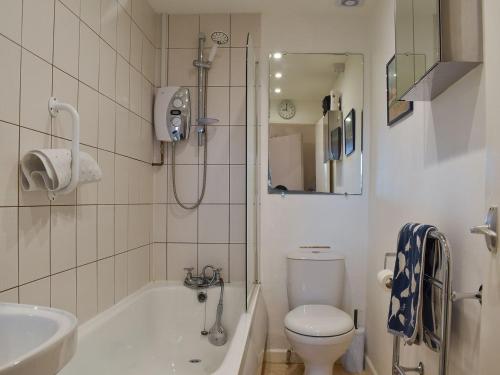 a bathroom with a toilet and a tub and a sink at Flat 2 Beachview - Ukc4220 in Lowestoft