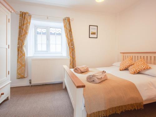 a bedroom with two beds and a window at Half Penny Cottage in Docking