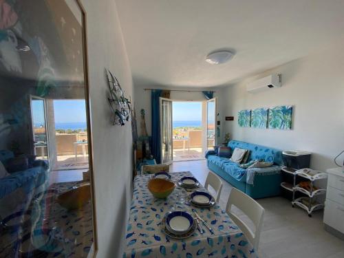 Una sala de estar con una mesa y un sofá azul. en Marina Smeraldo, en Castelsardo