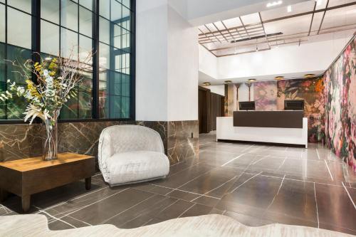 a lobby with a chair and a couch and a table at Hyatt Centric Midtown 5th Avenue New York in New York
