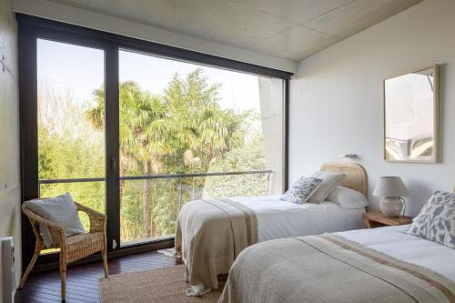 1 dormitorio con 2 camas y ventana grande en Amazing Villa in San Sebastián by SanSe Holidays, en San Sebastián