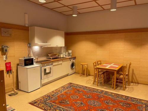 a kitchen with a table and a refrigerator and a stove at Juuri remontoitu kodikas asunto Anttolan satamassa in Anttola