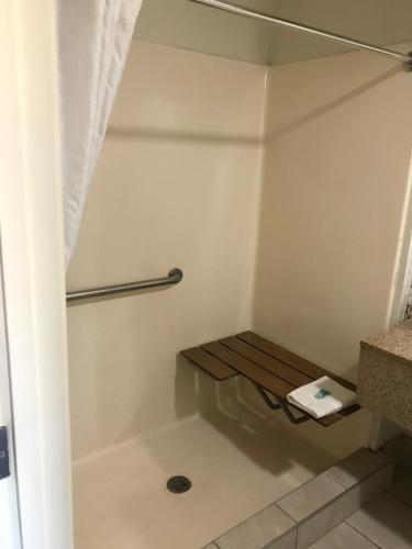 a shower with a bench in a bathroom at The Best Inn & Suites in Markham