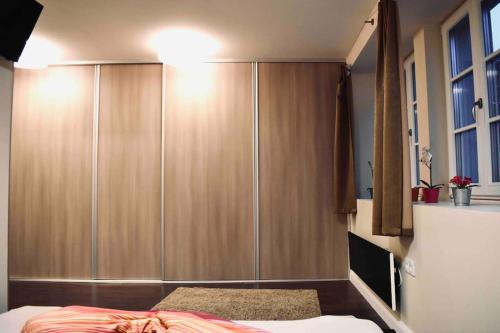 1 dormitorio con armario grande de madera y cama en Premium Casa Apartman en Sopron