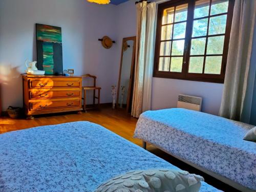 a bedroom with two beds and a dresser and a window at Villa Les Chariotins in Draguignan