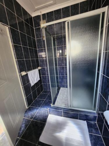 a bathroom with a shower with a glass door at Balmoral Cottage, West Beach in Cape Town