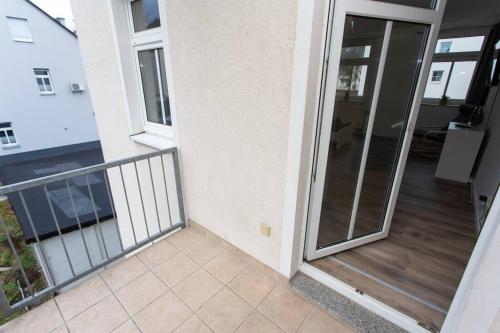 einen Balkon mit Glastür an einem Gebäude in der Unterkunft Schickes 1-Raum-Apartment mit Balkon und vollausgestatteter Küche in Chemnitz