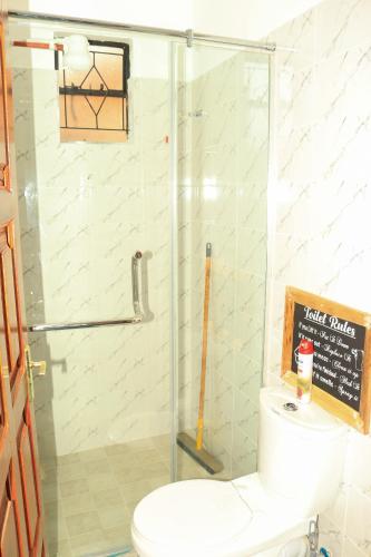 a bathroom with a toilet and a glass shower at Nook-HeArt Stays in Kakamega