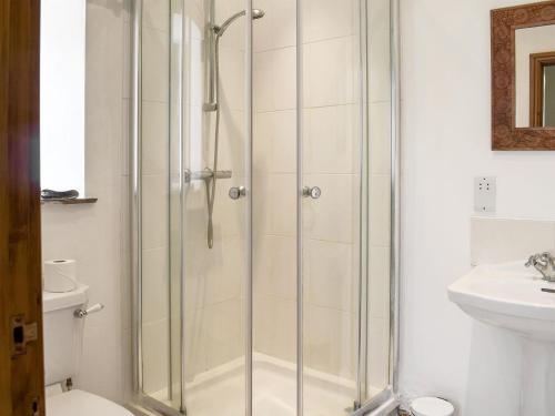 a shower with a glass door in a bathroom at Grisedale Coach House in Threshfield