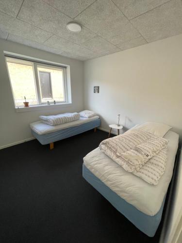 1 dormitorio con 2 camas y ventana en Nyt hus en Herning
