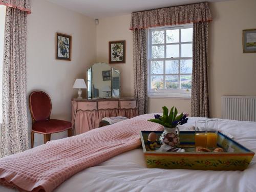 a bedroom with a bed with a tray of fruit on it at Easter Baldinnies in Forteviot