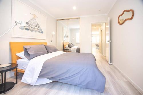 a bedroom with a large bed and a living room at Luxury modern CBD ground floor apartment. in Canberra
