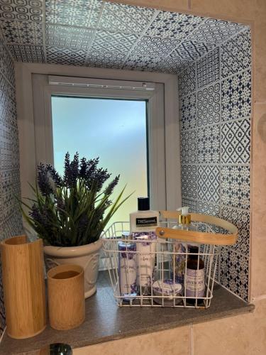 a bathroom with a window and a shelf with cosmetics at Lavender Den in London