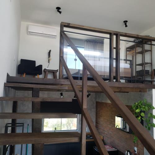 a staircase in a loft with a large window at The Guest House hostel in Balneário Gaivotas