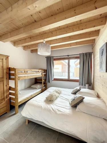 two bunk beds in a room with wooden ceilings at Chalet Le Gebroulaz in La Toussuire