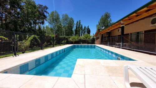 una piscina con suelo de baldosa y una valla en Reina Mora en San Rafael