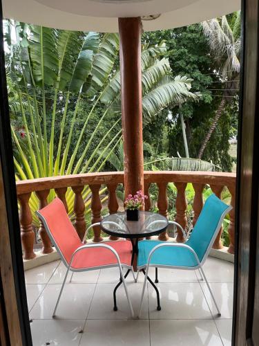 um pátio com 3 cadeiras e uma mesa na varanda em Stay In Style Lodge em Dar es Salaam