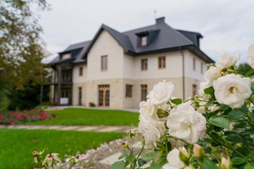 una casa grande con flores blancas delante en Siedlisko Marianna, apartamenty Janowiec, Kazimierz Dolny, en Ławecko