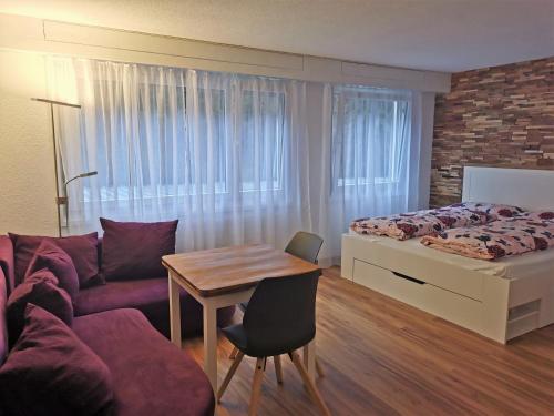 a bedroom with a bed and a table and a couch at Modern renoviert mit Hallenbad + Fitness in Laax