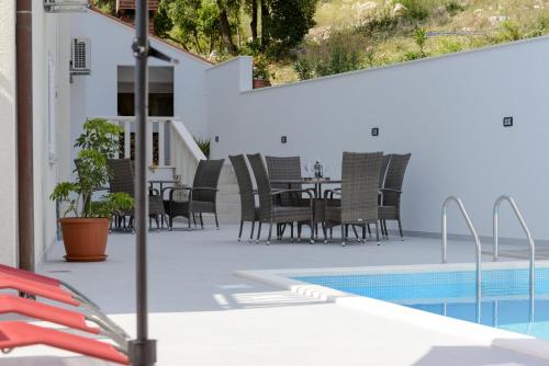 un patio con mesa y sillas junto a una piscina en Villa Bingo en Cavtat