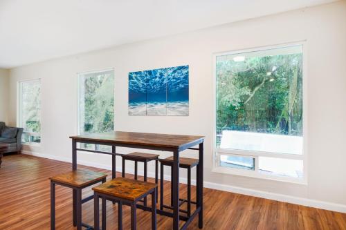 a table and two stools in a room with two windows at Puni Mauka 31 plus day rental in Pahoa