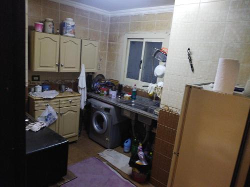 uma cozinha com um lavatório e uma máquina de lavar roupa em شقة النجم ترى دائرى المعادى مباشرة no Cairo